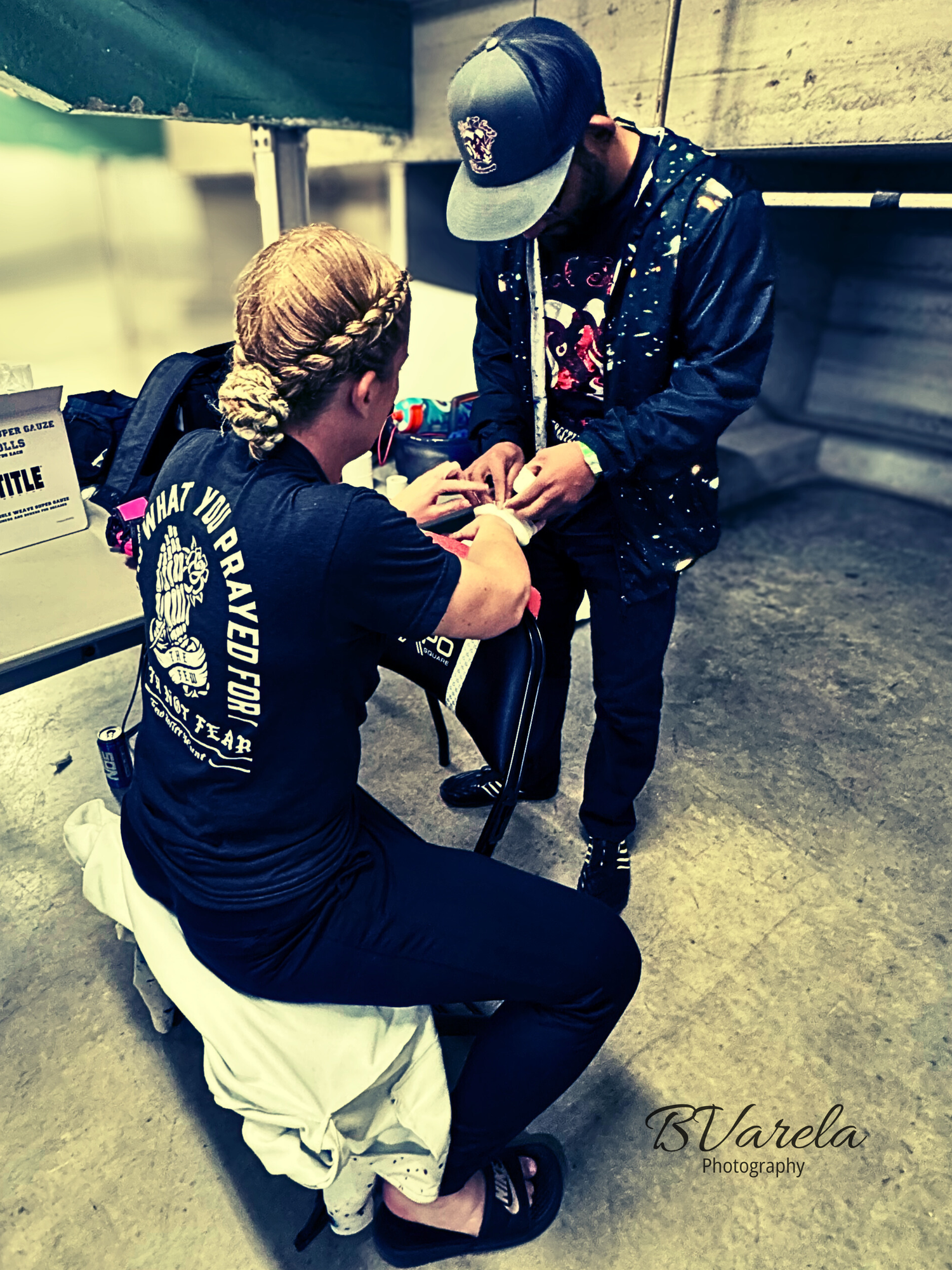 Athlete getting hands wrapped by trainer backstage before a martial arts competition. sport photographer