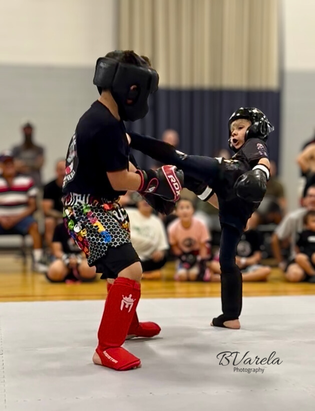Young martial arts competitors sparring with kicks during a youth kickboxing tournament. sport photographer