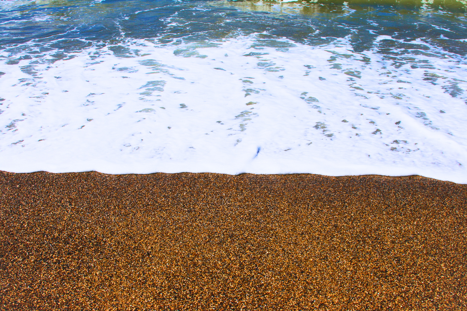 Ocean waves washing over a golden pebble beach creating a beautiful natural shoreline pattern., half moon bay, photographer