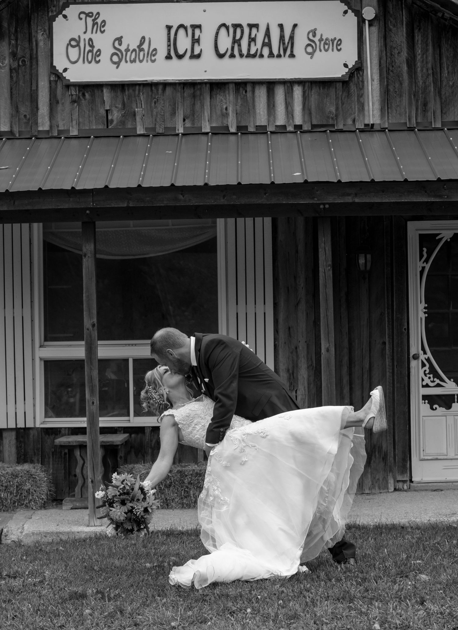 Black and white photo with the groom dipping his bride