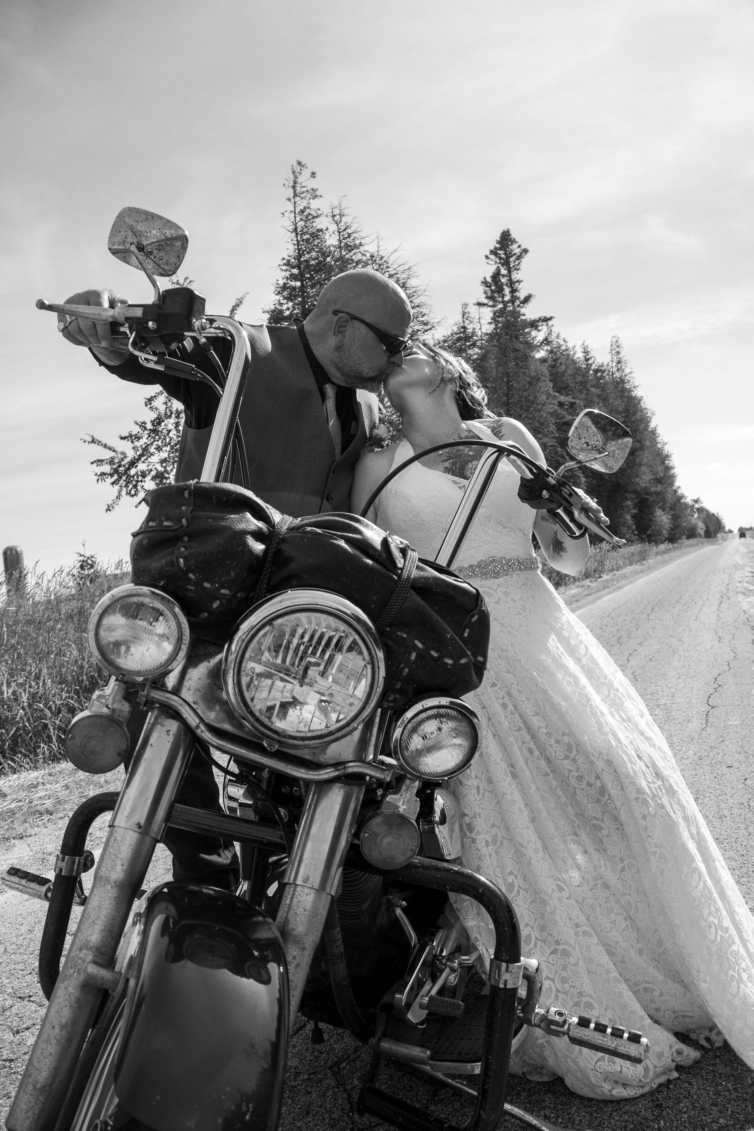 Bride and groom kissing on a motorcycle