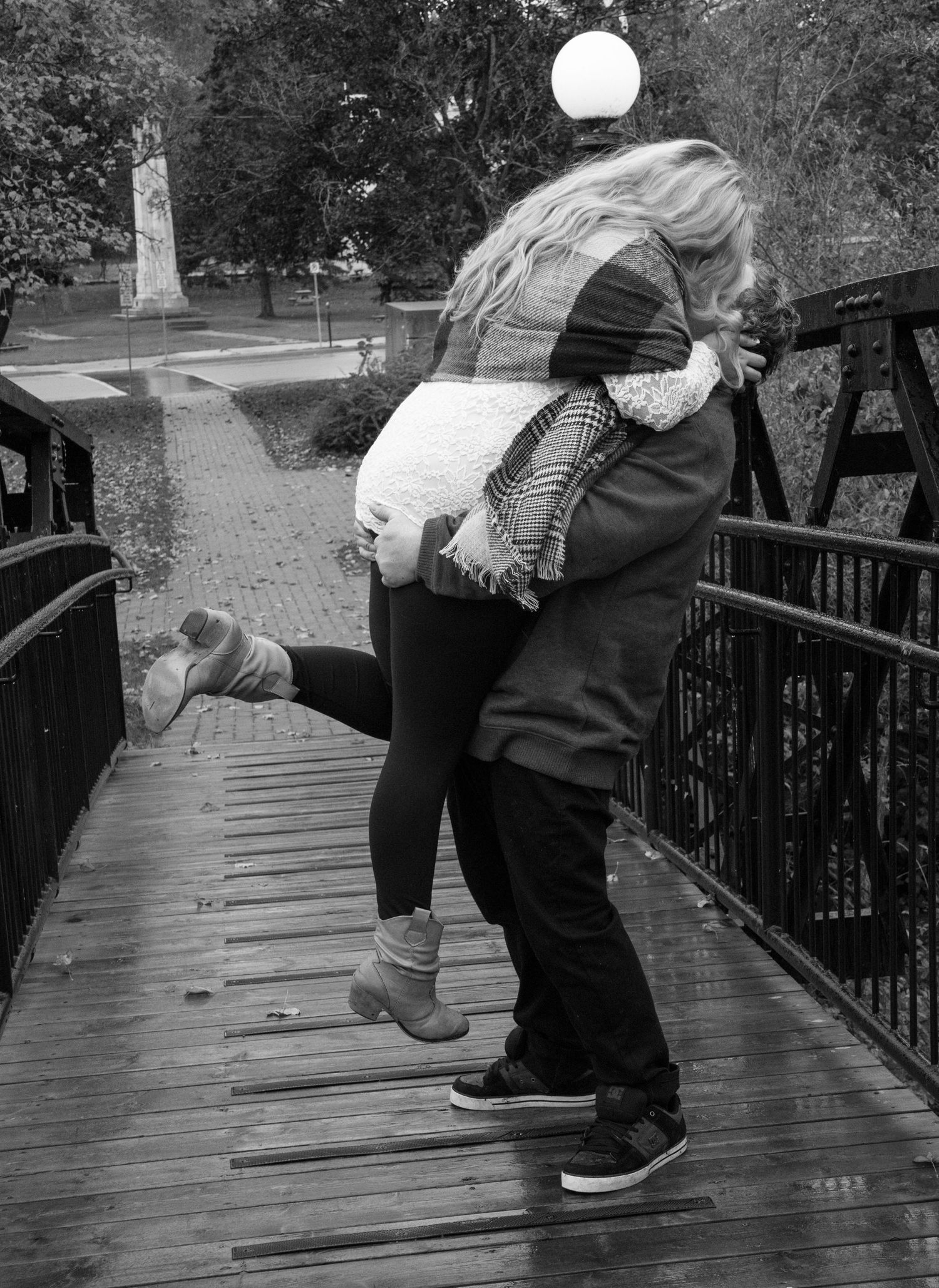 A man holding a lady up high while kissing