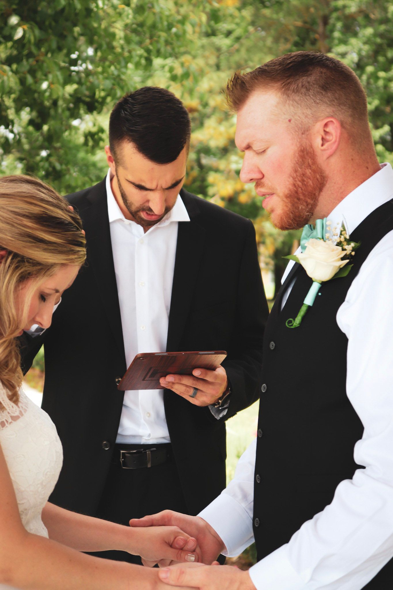 A sequence of wedding photos showing people looking down at phones during an outdoor ceremony.