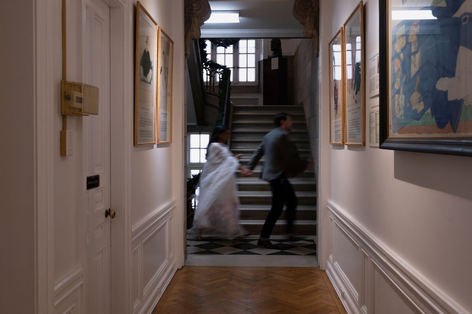 A couple hold hands and run past a hallway inside Chicago's International Museum of Surgical Science.