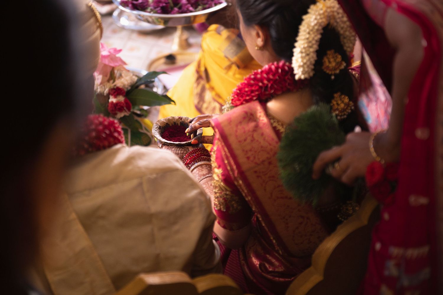 A bride participates in Tamil traditions at her wedding.