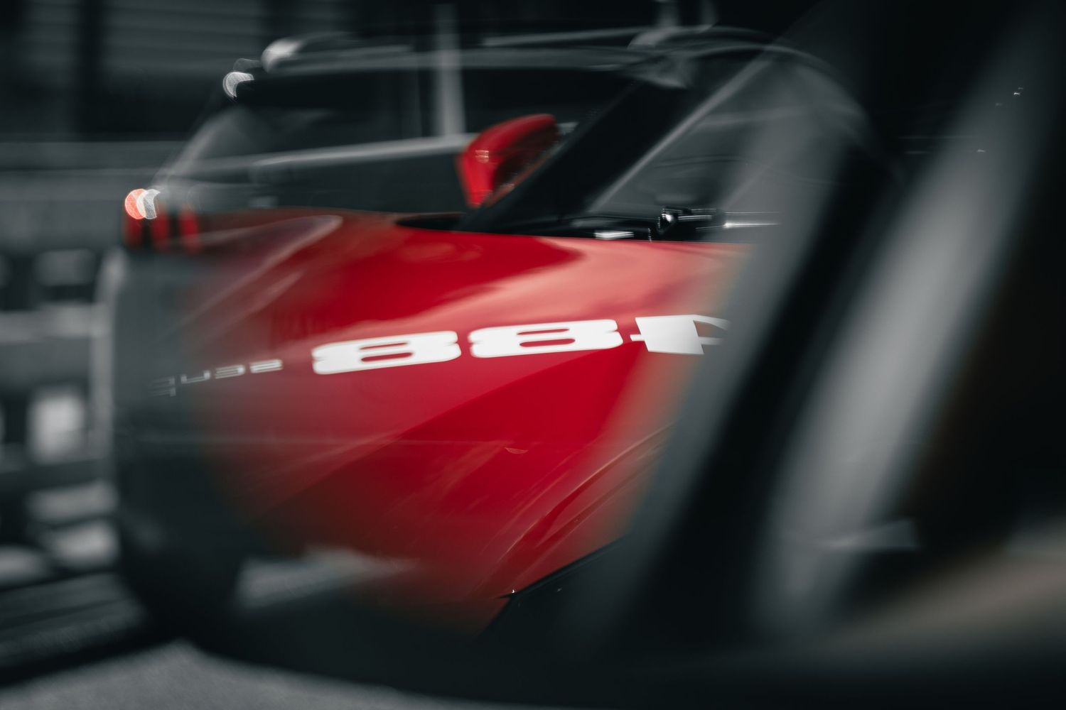 Blurred artistic shot of a red vehicle with selective focus on SEAT branding.
