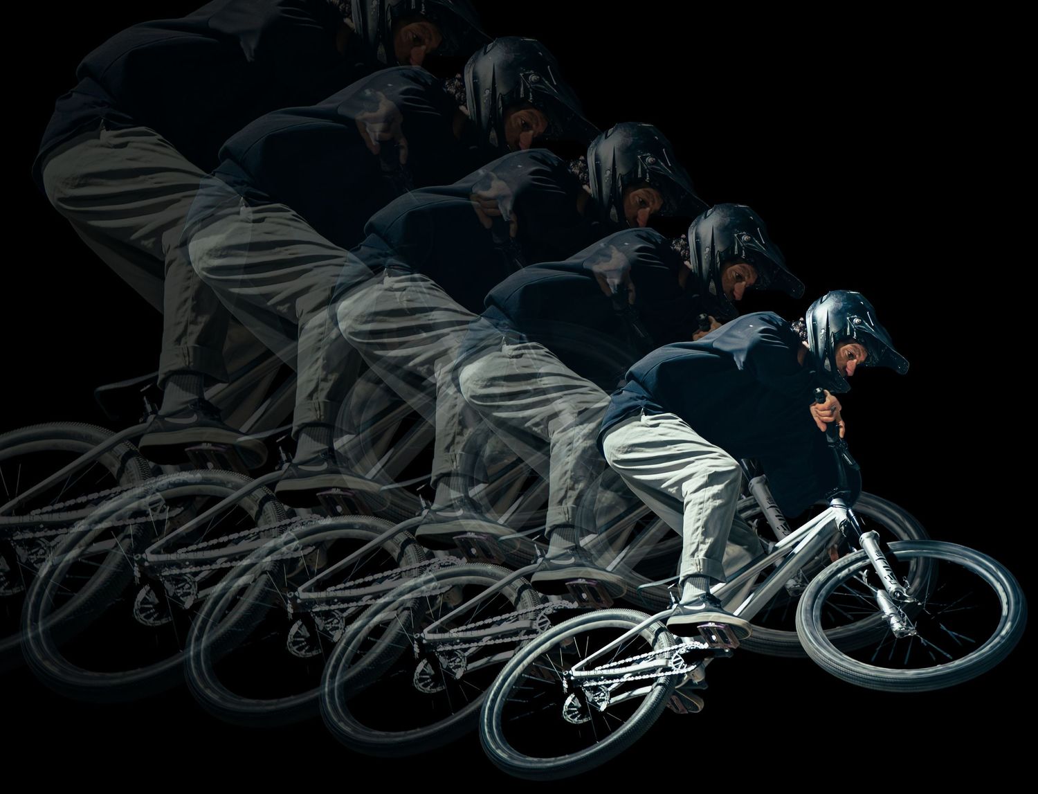 Multiple exposure sequence photo showing a BMX rider performing a dramatic jump trick in dark lighting conditions.