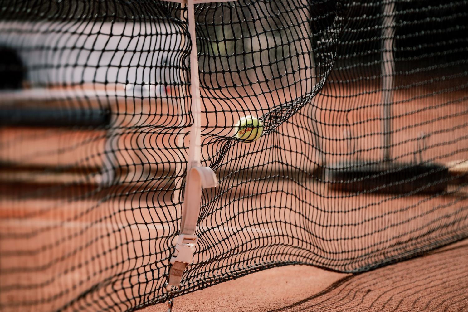 Close-up detail of a distorted tennis court net creating abstract patterns and shadows.