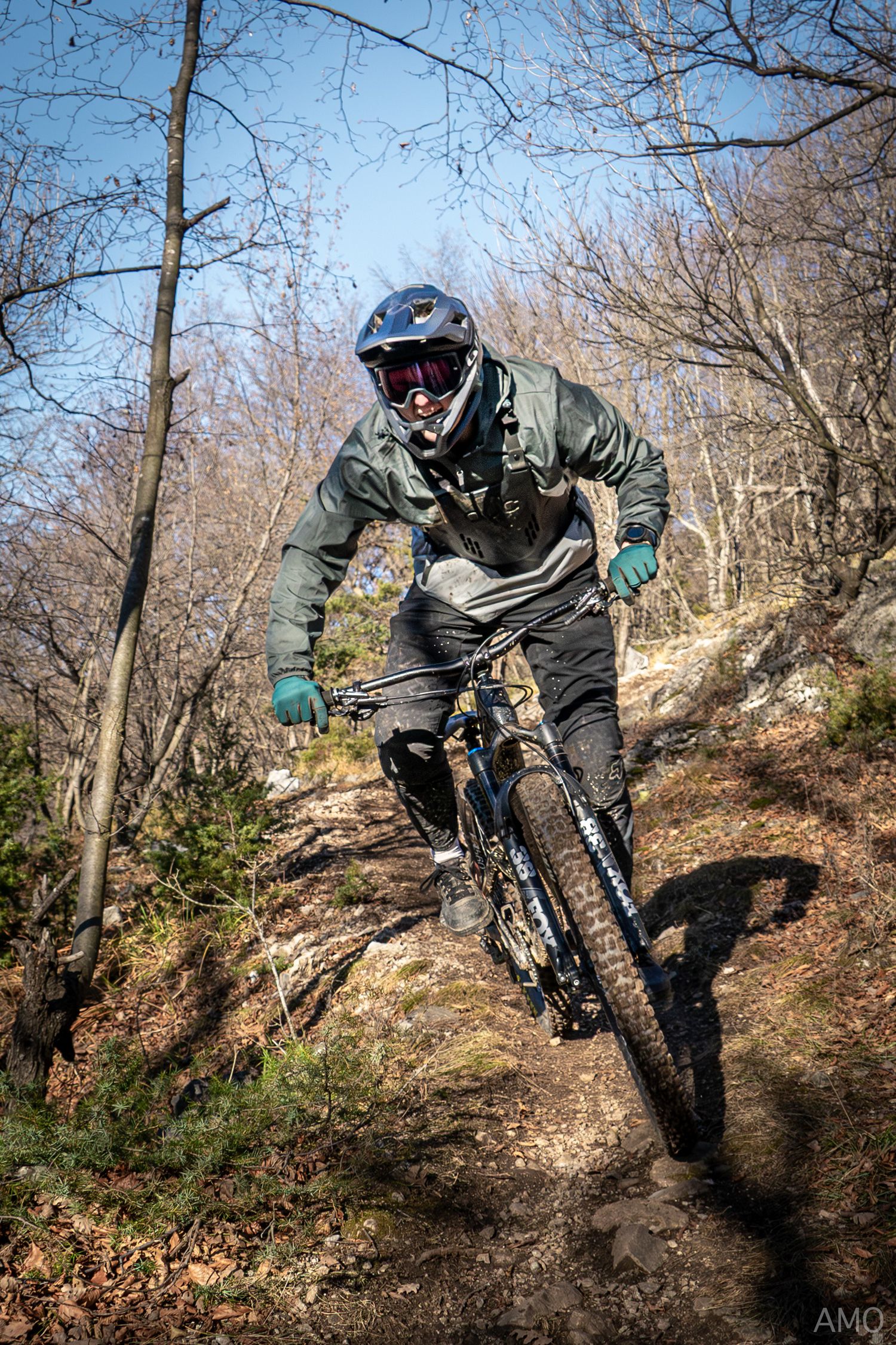 Mountain biker navigating rocky terrain on a challenging forest trail.