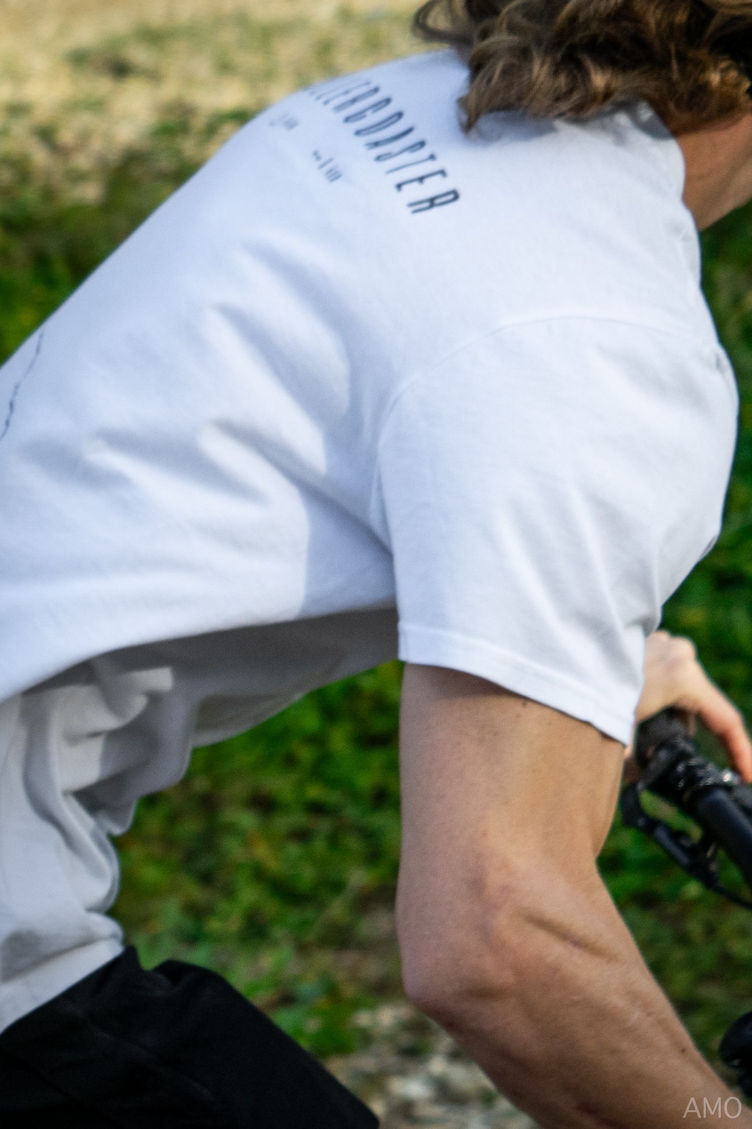 Close-up of white athletic shirt sleeve during mountain biking action shot.
