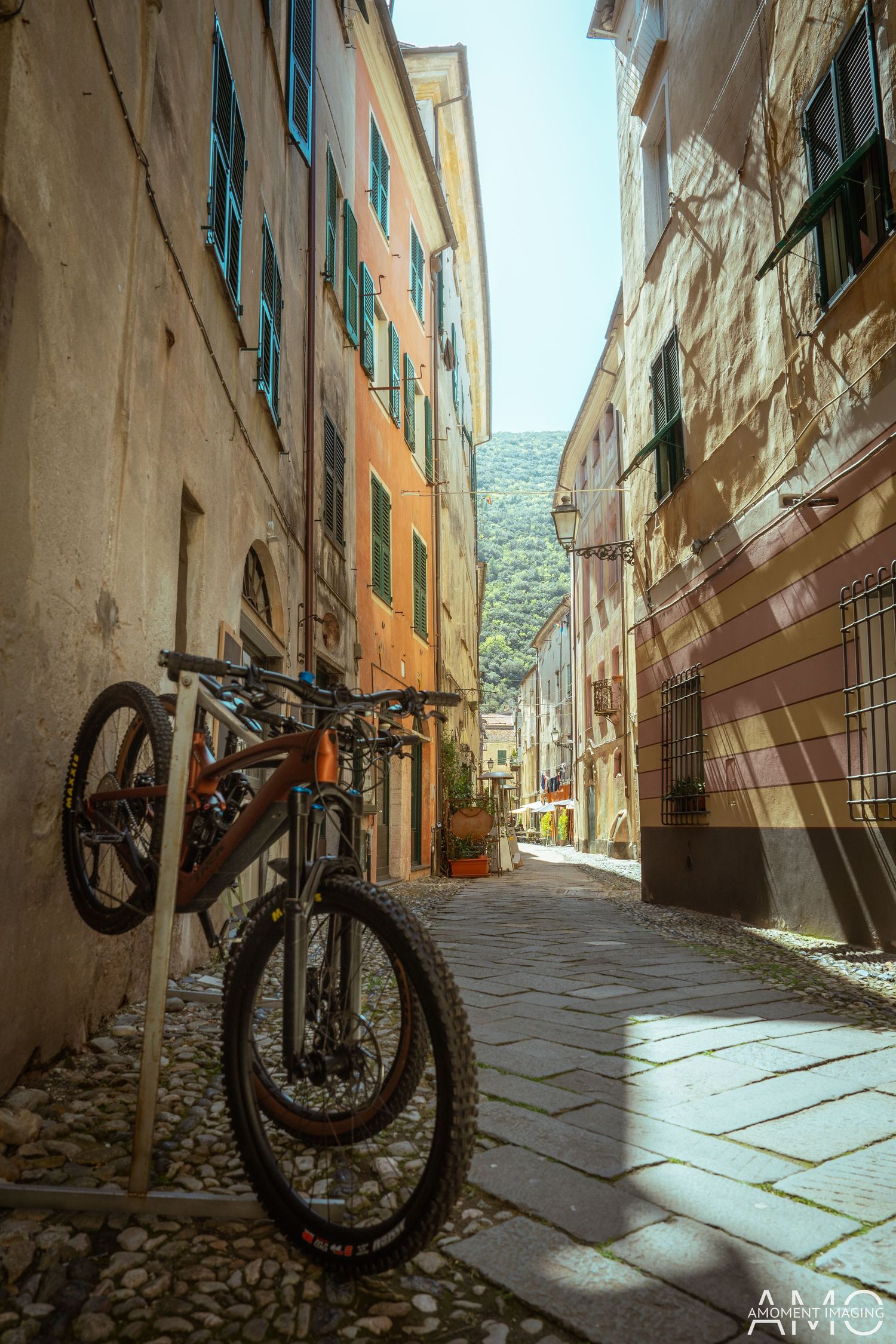 Mountain bike parked against wall in narrow Mediterranean alleyway.