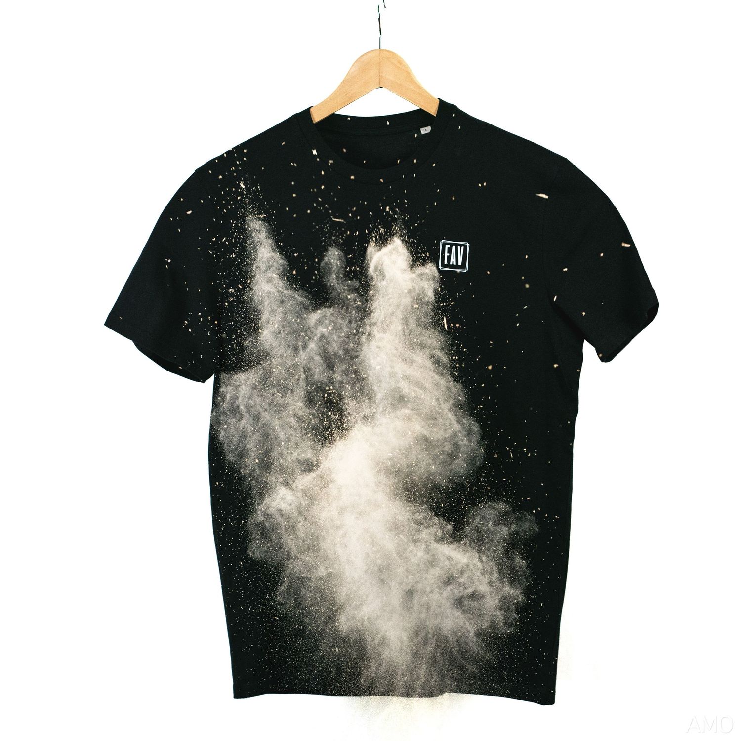 Black t-shirt with dynamic white powder explosion design hanging on wooden hanger.