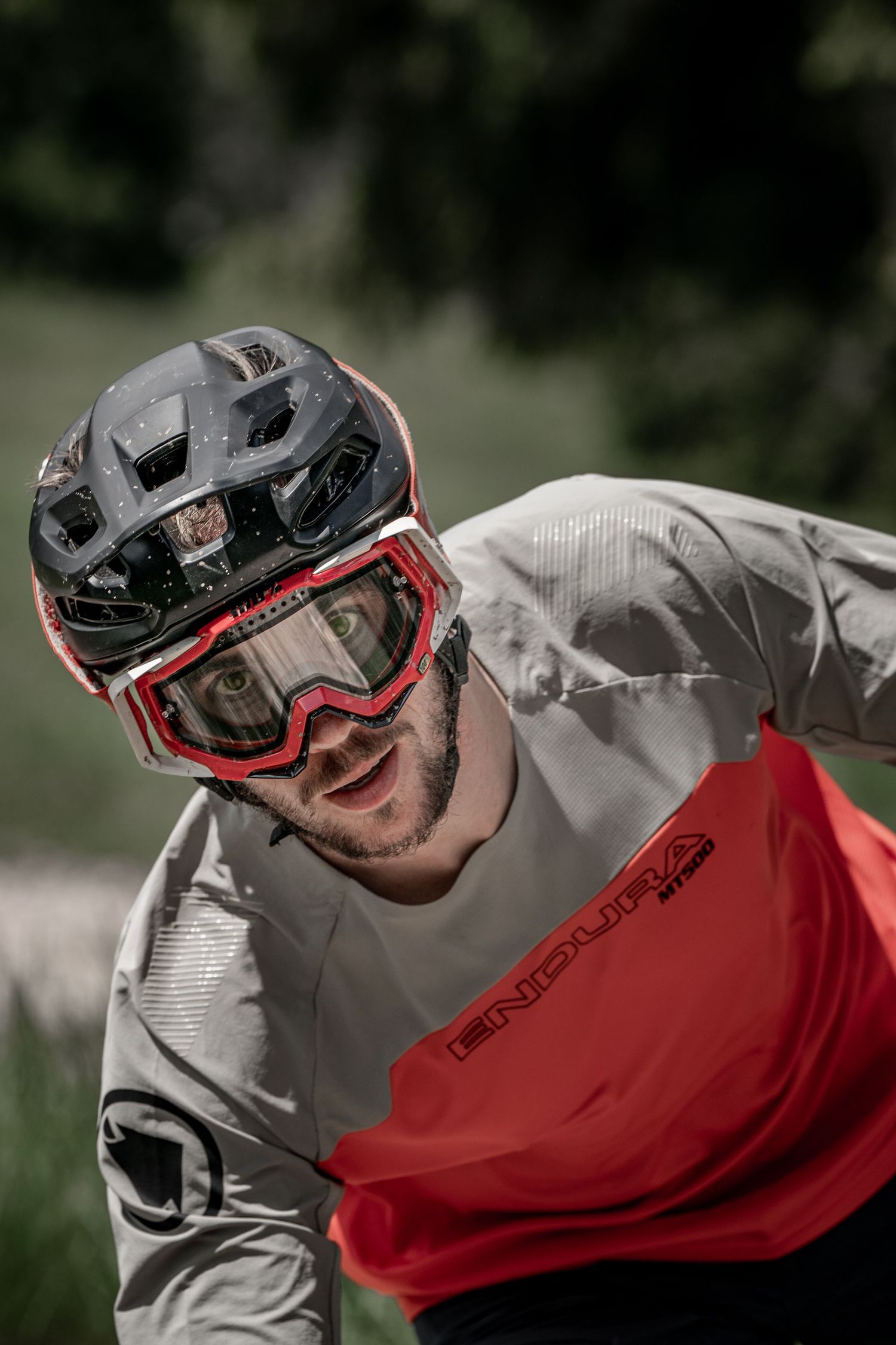 Mountain biker wearing protective helmet and goggles during trail ride.