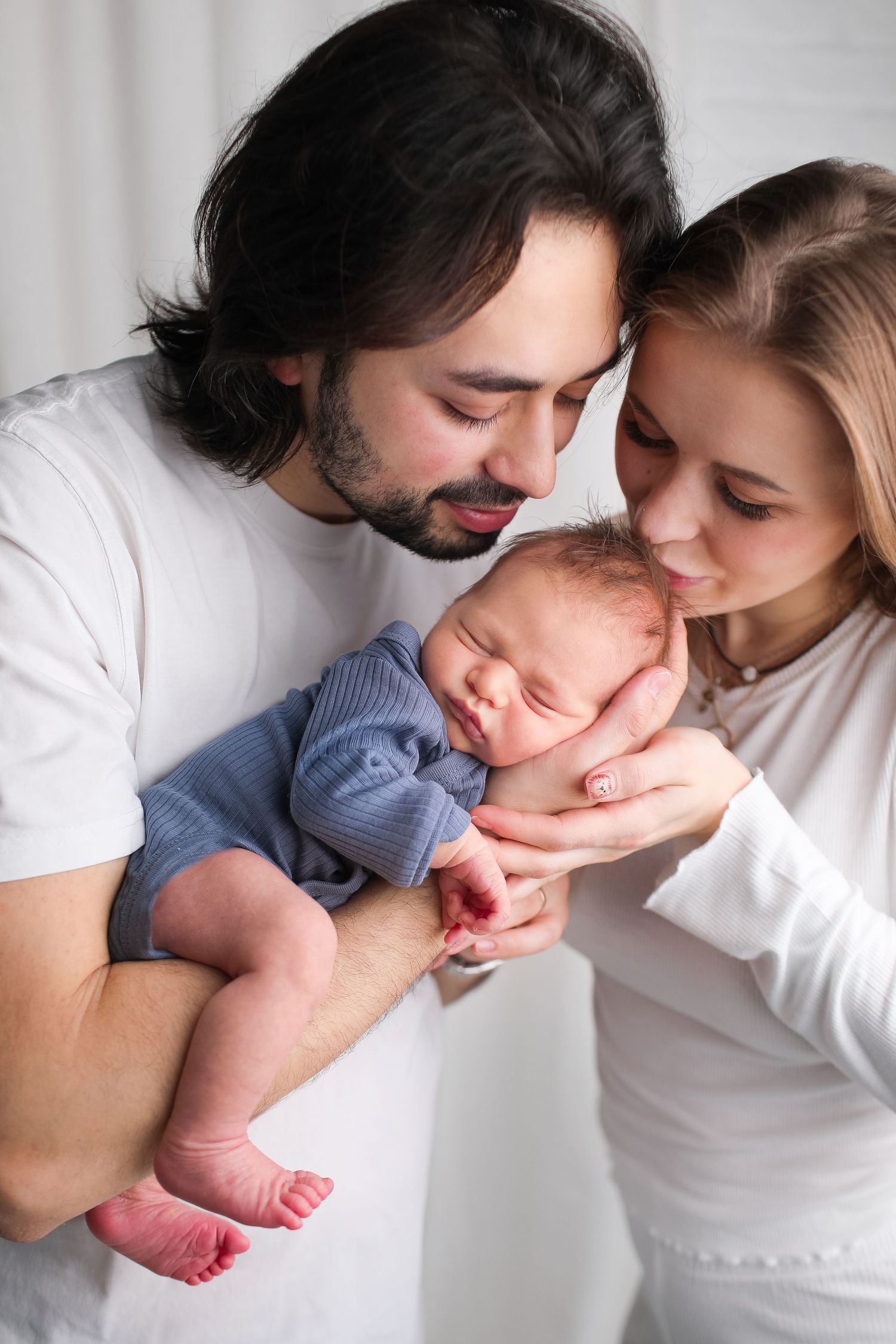 Intimate newborn photography with sleeping baby in soft natural light.