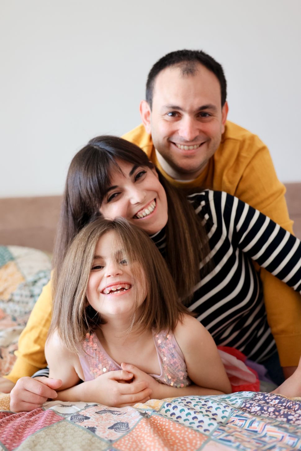 Happy family spending quality time together on a colorful patchwork quilt.
