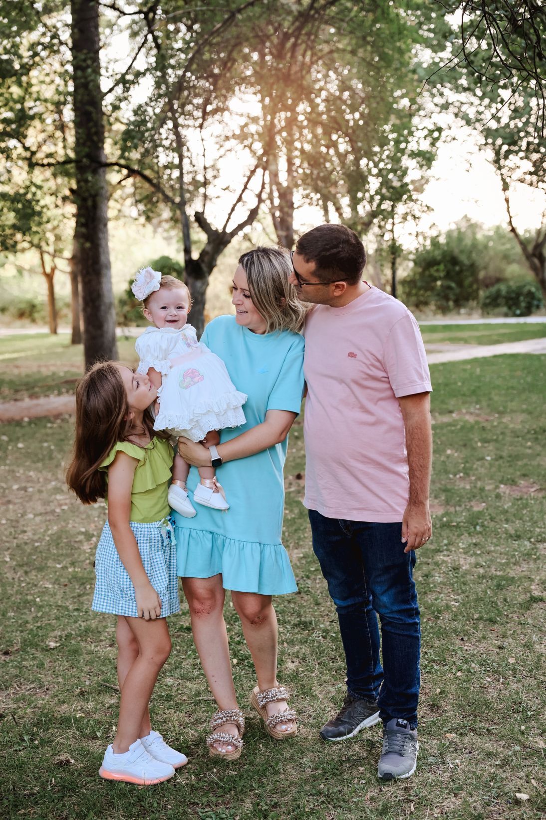 A family enjoying a sunny day together in a park setting.