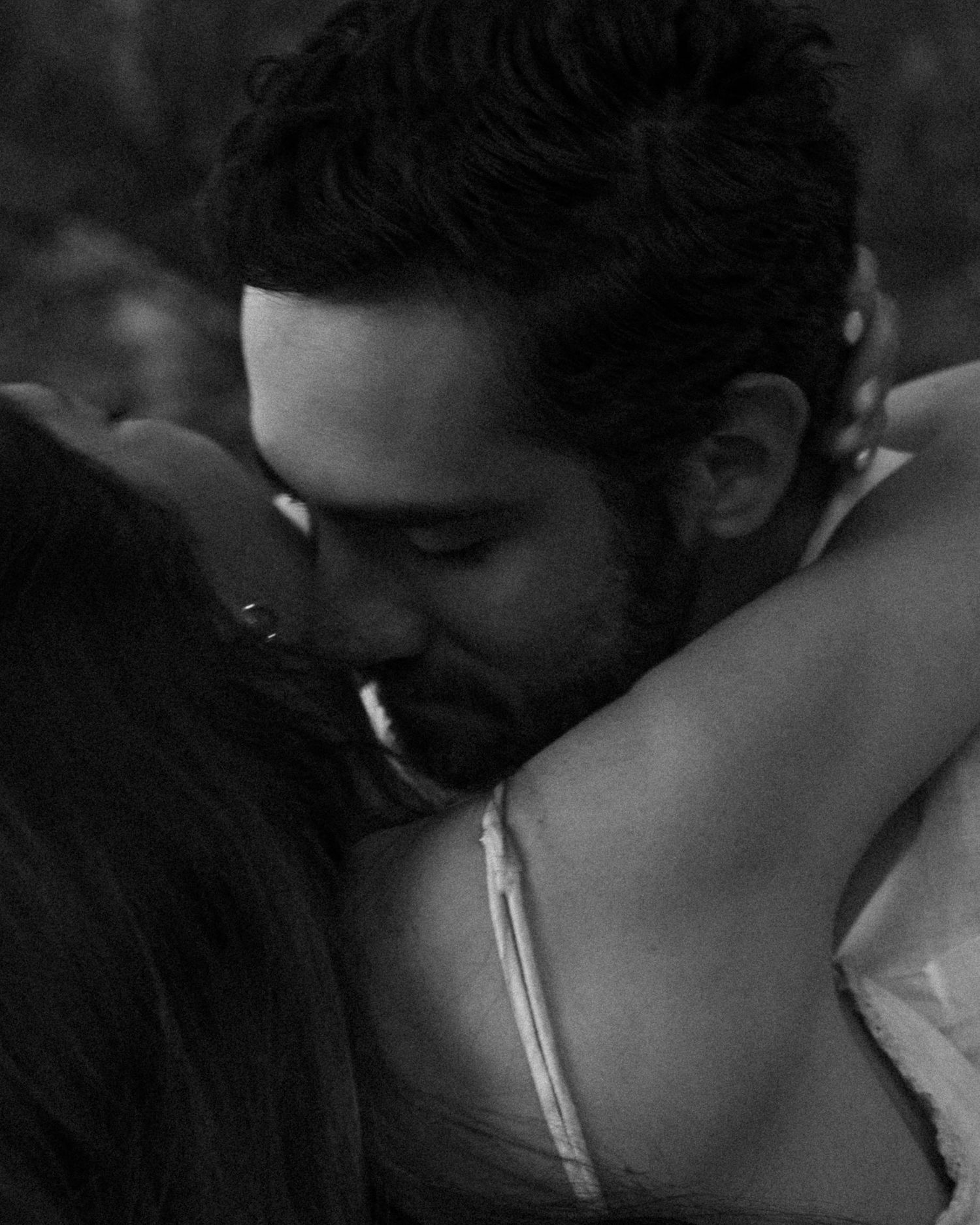 Romantic black and white close-up of a couple sharing an intimate embrace and kiss.
