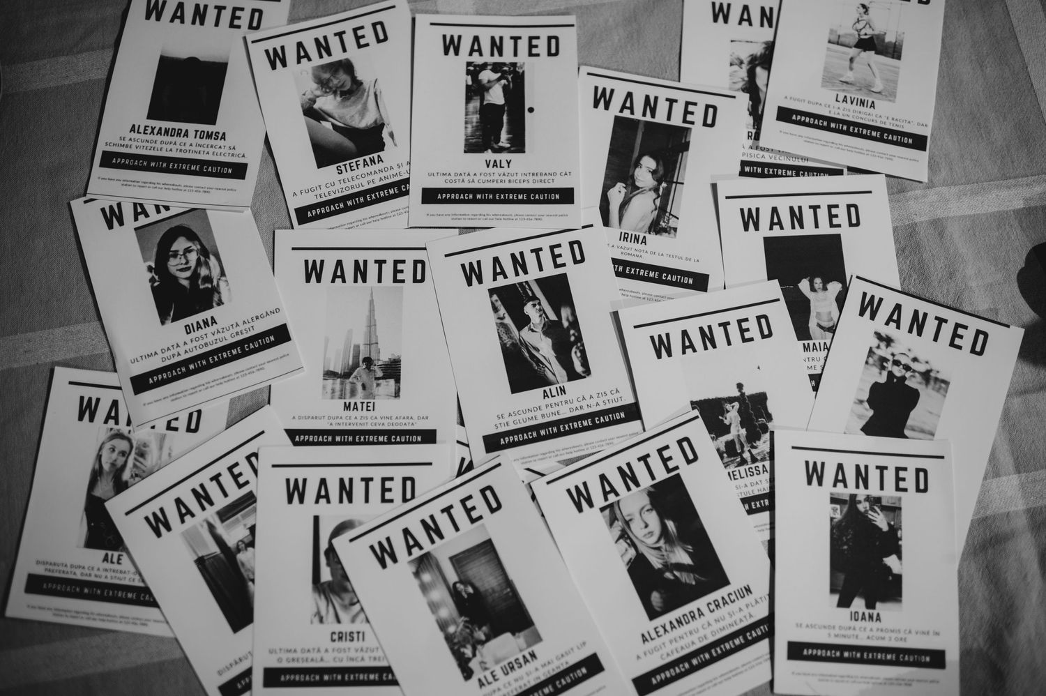 Collection of black and white Wanted poster props spread on floor for Halloween party decoration.