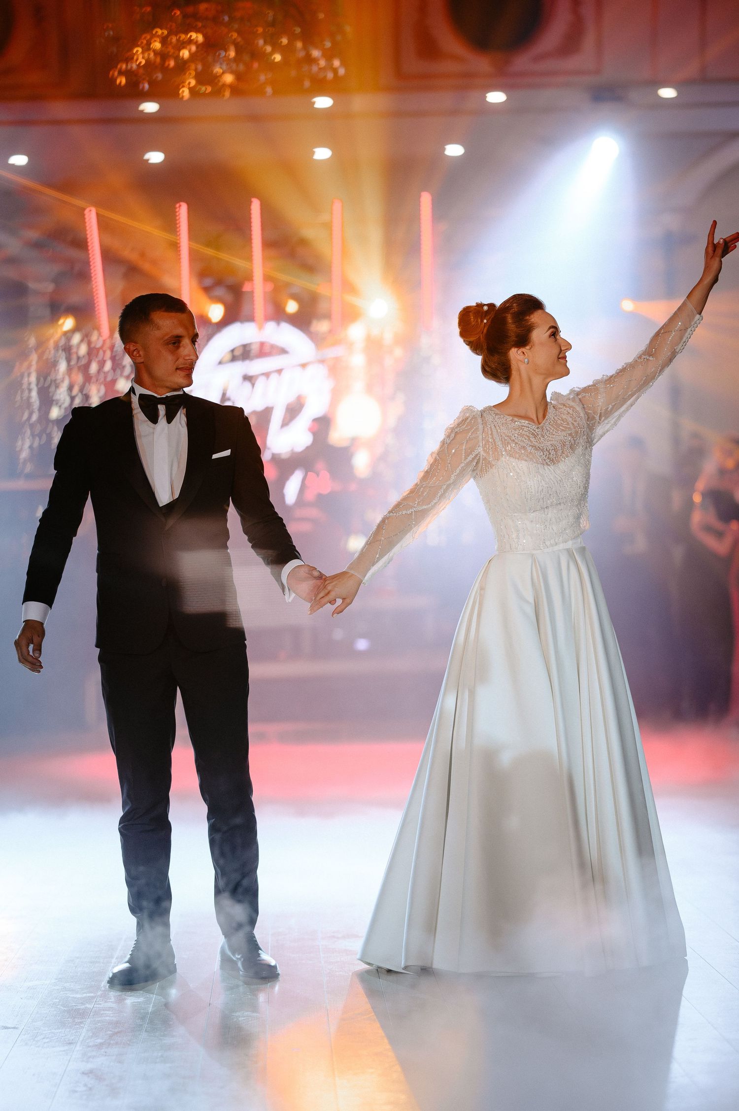 Elegant couple performing their first dance on a dramatic fog-filled wedding reception dance floor.