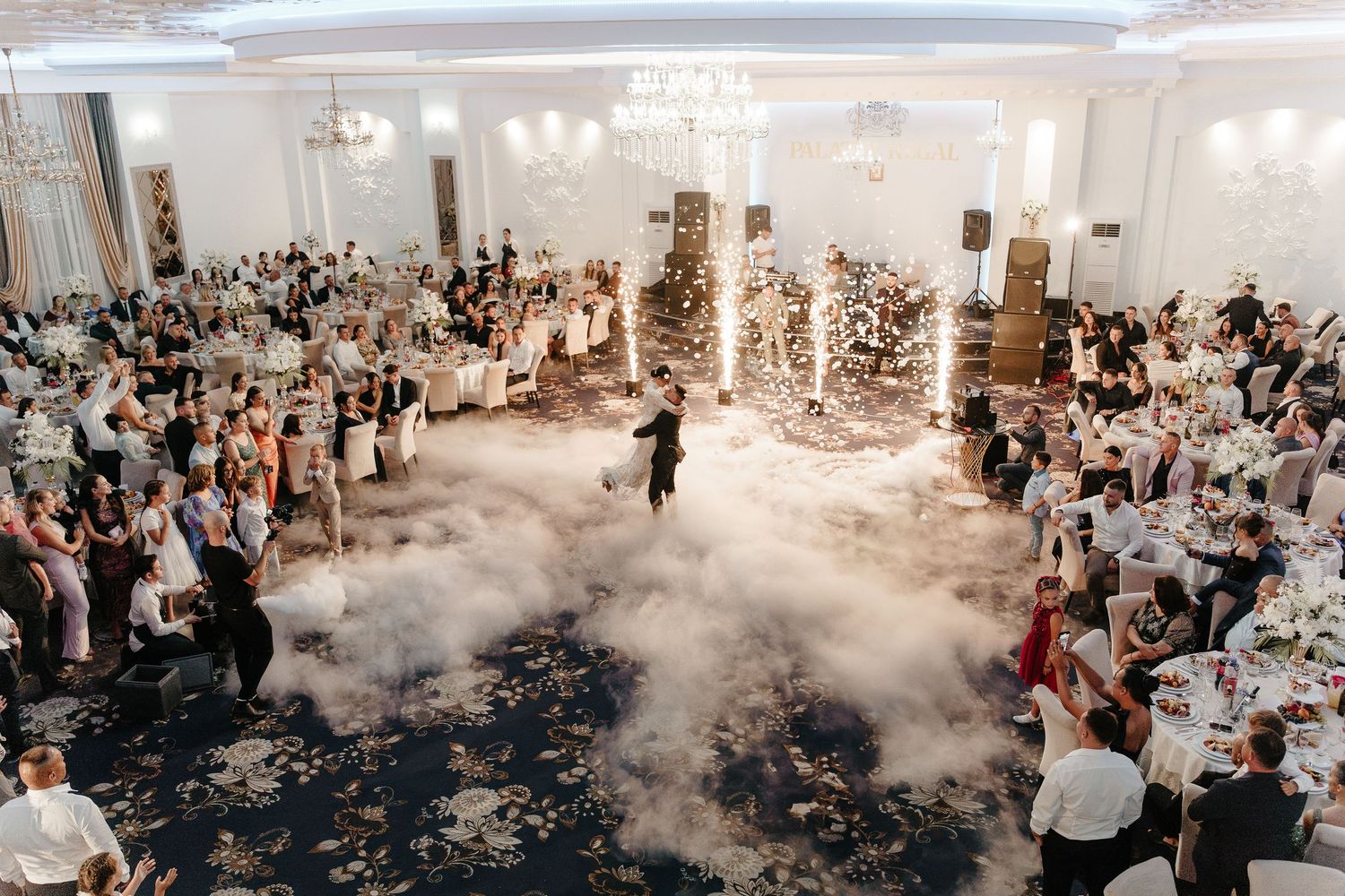 Aerial view of wedding first dance with dramatic dry ice fog filling grand ballroom dance floor.