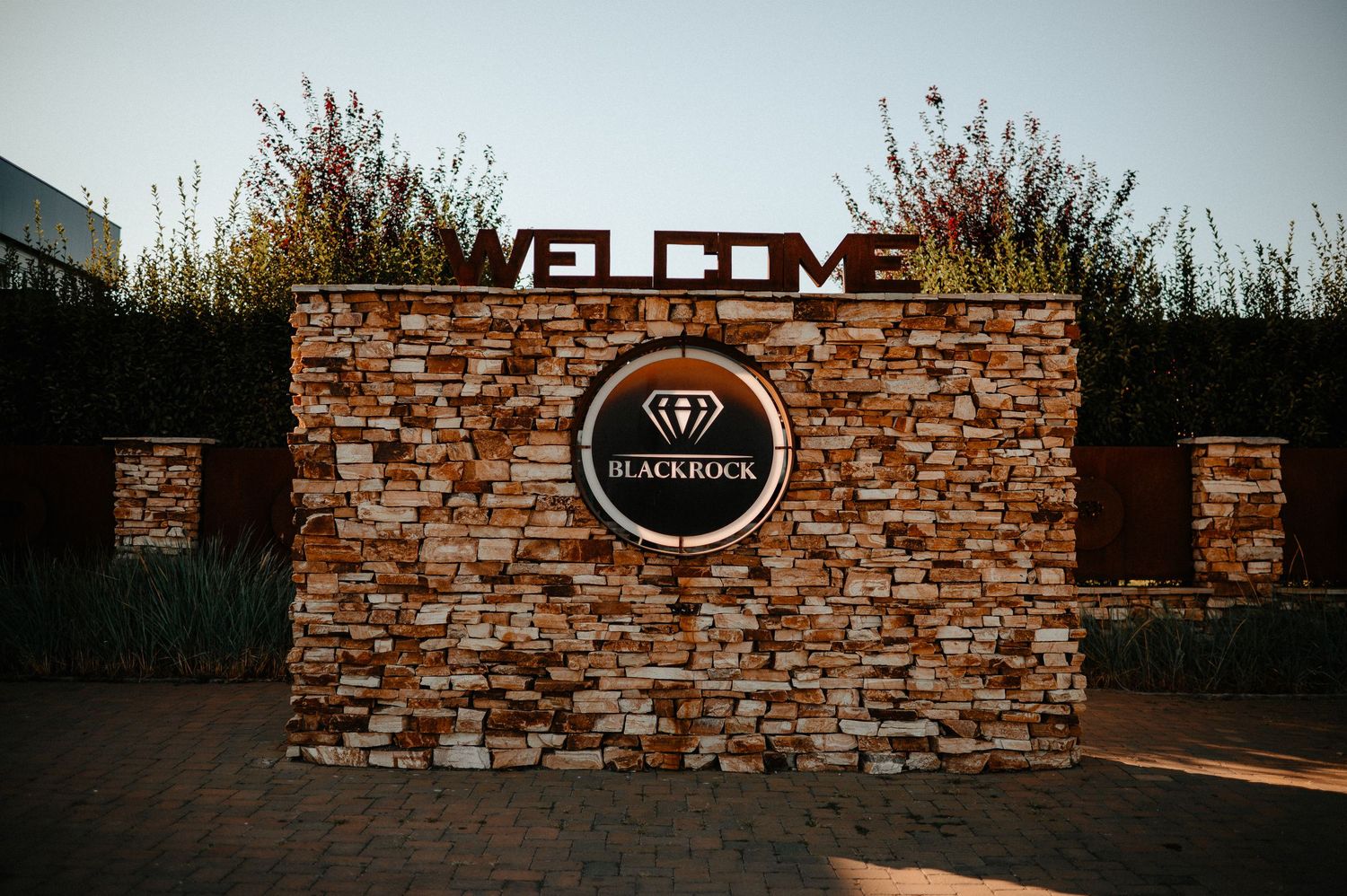 Stone welcome sign for Blackrock wedding venue illuminated at dusk.