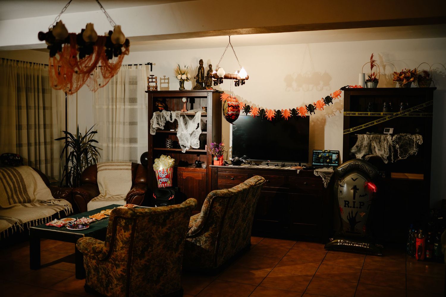 Cozy living room decorated with Halloween-themed ornaments, garlands, and spooky decor.