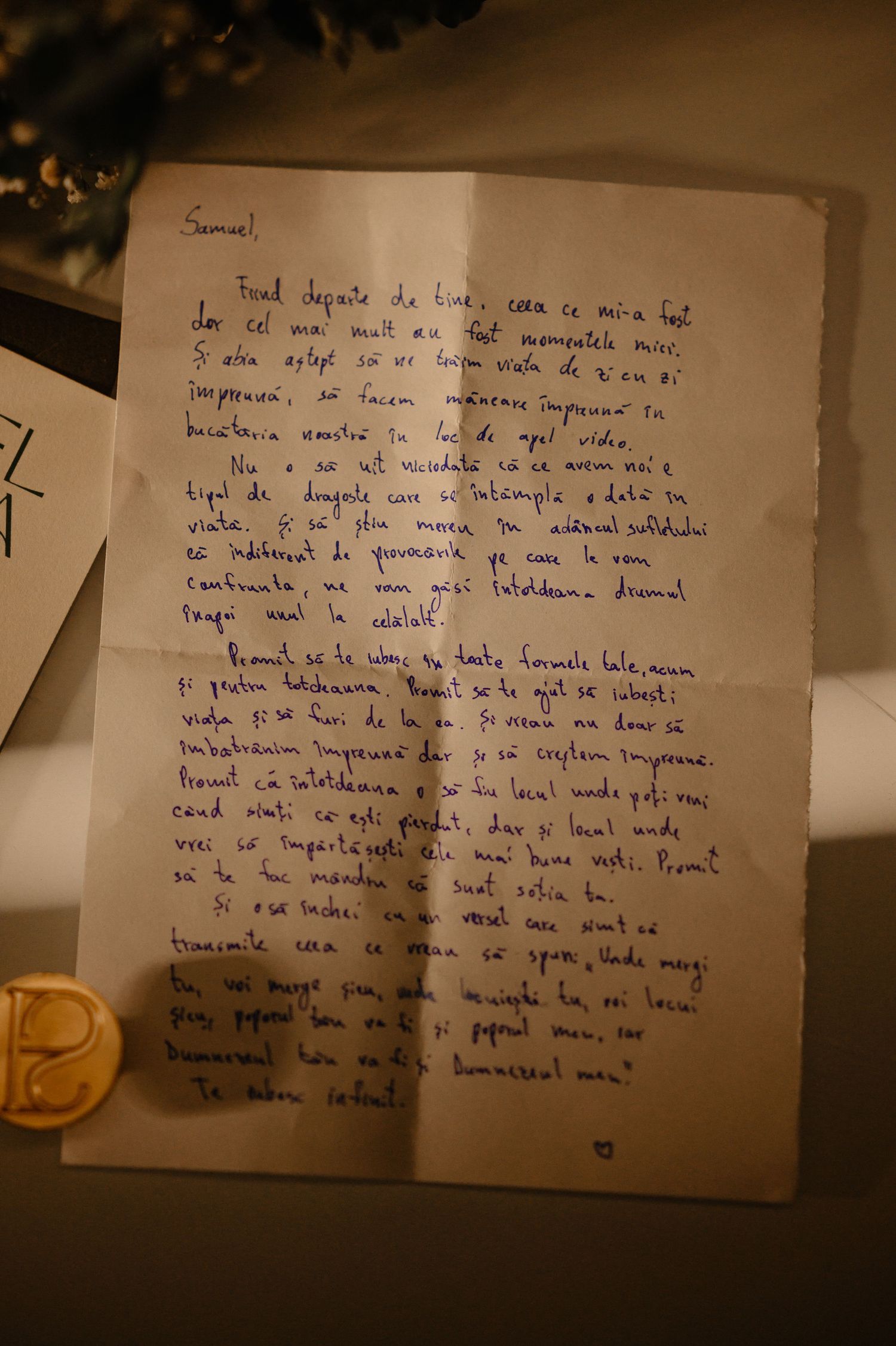 Handwritten wedding vow letter in Romanian script on aged paper in warm light.