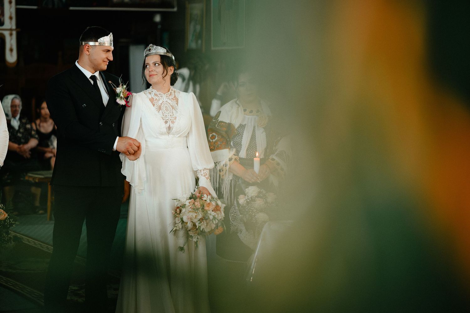 Bride and groom standing together during wedding ceremony in decorated church.