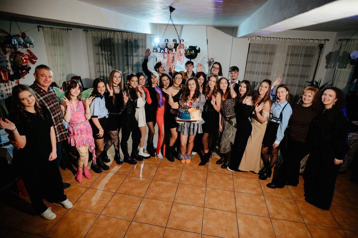 Large group photo of guests celebrating at an 18th birthday party indoors with balloons and decorations.