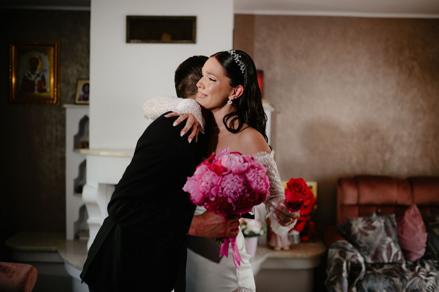 Bride and groom share warm embrace during first look holding colorful wedding bouquets.