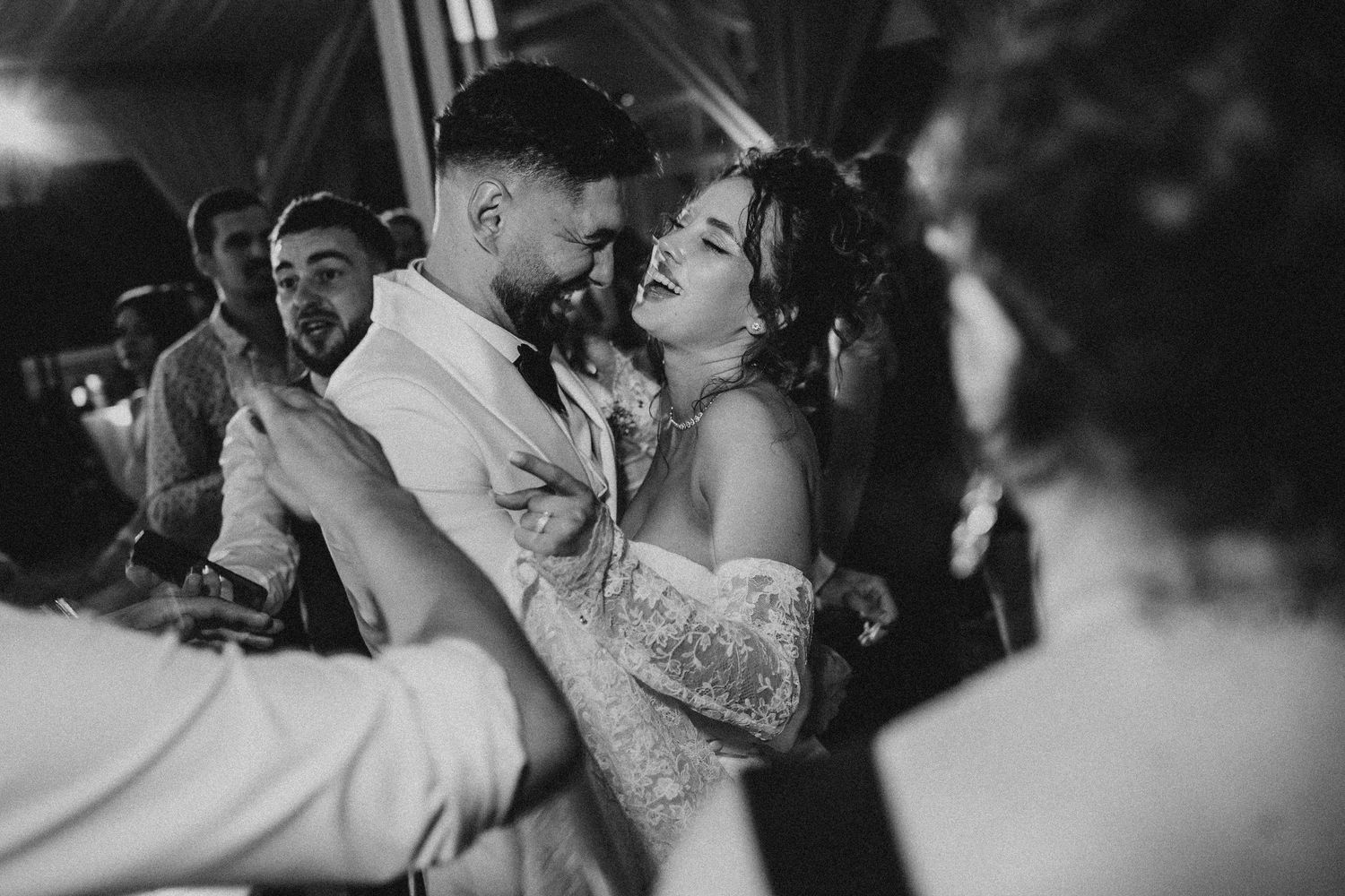 Black and white photo of a bride and groom sharing a romantic dance at their wedding reception.