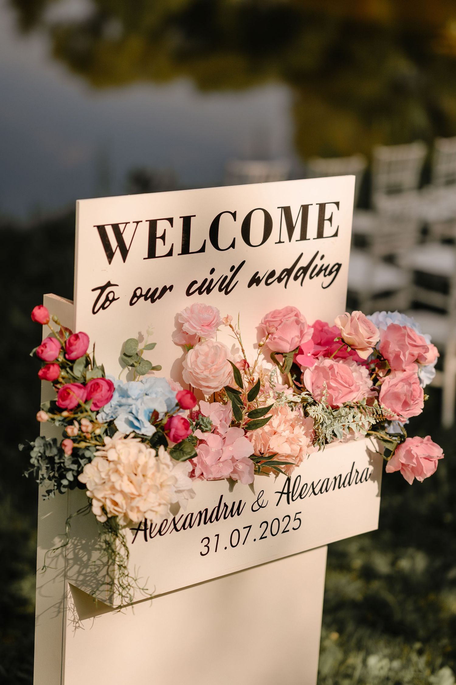 Welcome sign for Alexandru and Alexandra civil wedding on 31.07.2025 adorned with pink flowers.