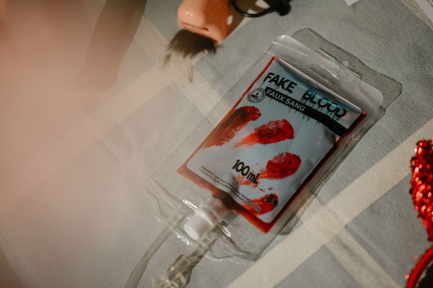 A bag of fake blood Halloween prop labeled as costume accessory lying on a table.