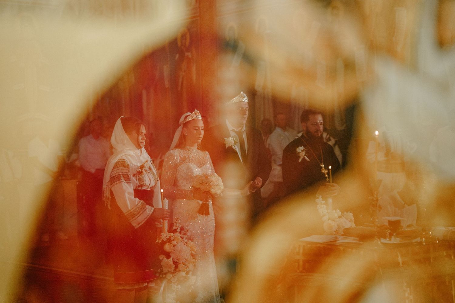 Blurred reflection of a wedding ceremony with bride and groom at the altar in a warmly lit church.