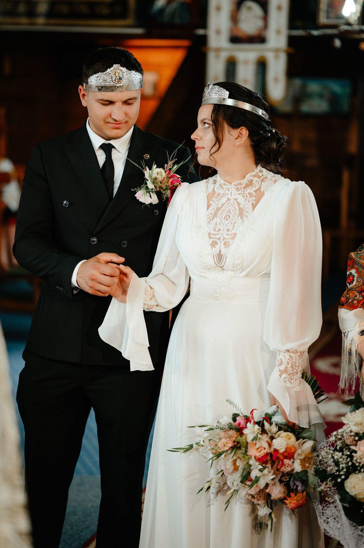 Bride and groom exchanging rings during Orthodox church wedding ceremony.
