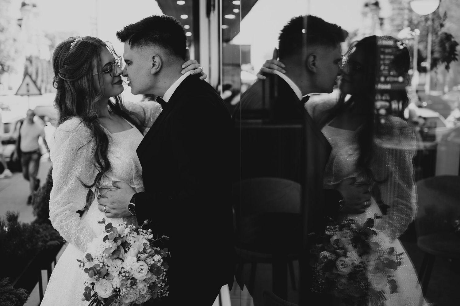 Black and white wedding portrait of couple nearly kissing reflected in a storefront window.