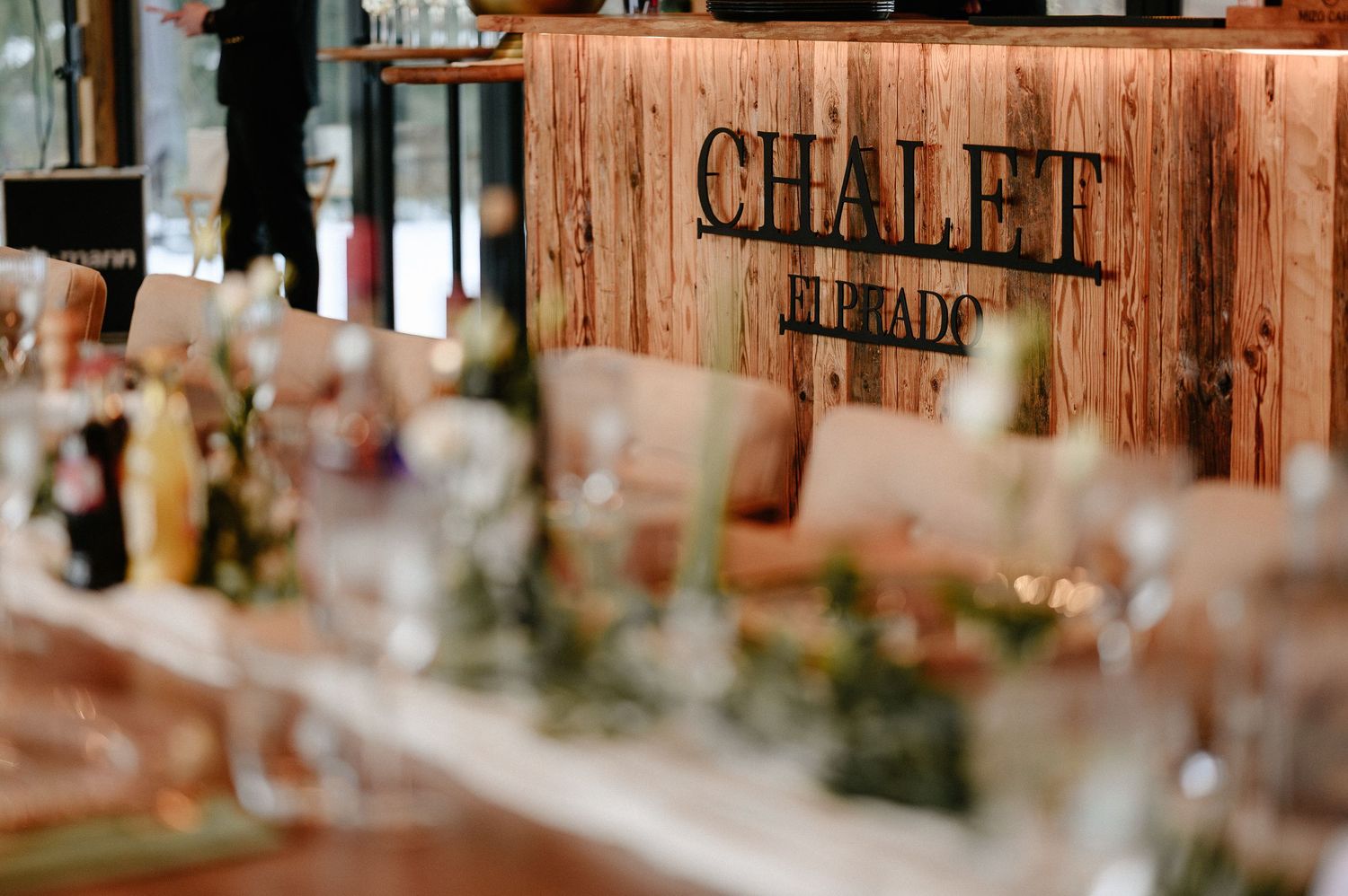 Long dining table set for an event at Chalet El Prado restaurant with rustic wooden decor.