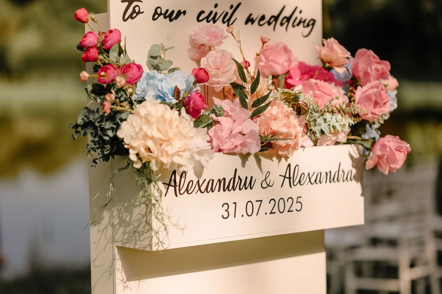 Close-up of civil wedding welcome sign for Alexandru and Alexandra dated 31.07.2025 with blooms.