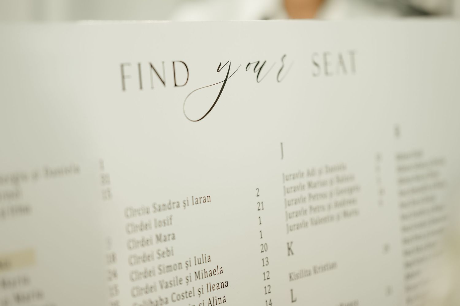 Close-up of elegant wedding seating chart with find your seat calligraphy header.