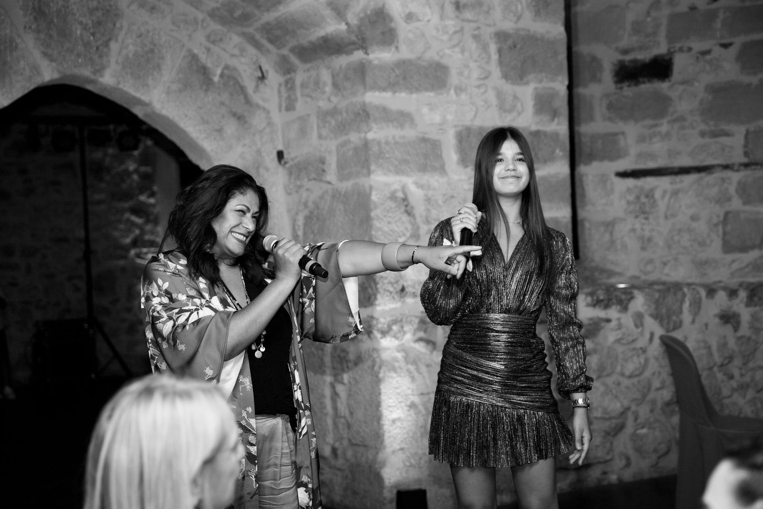 Black and white photo of two women performing or speaking at a wedding reception event.