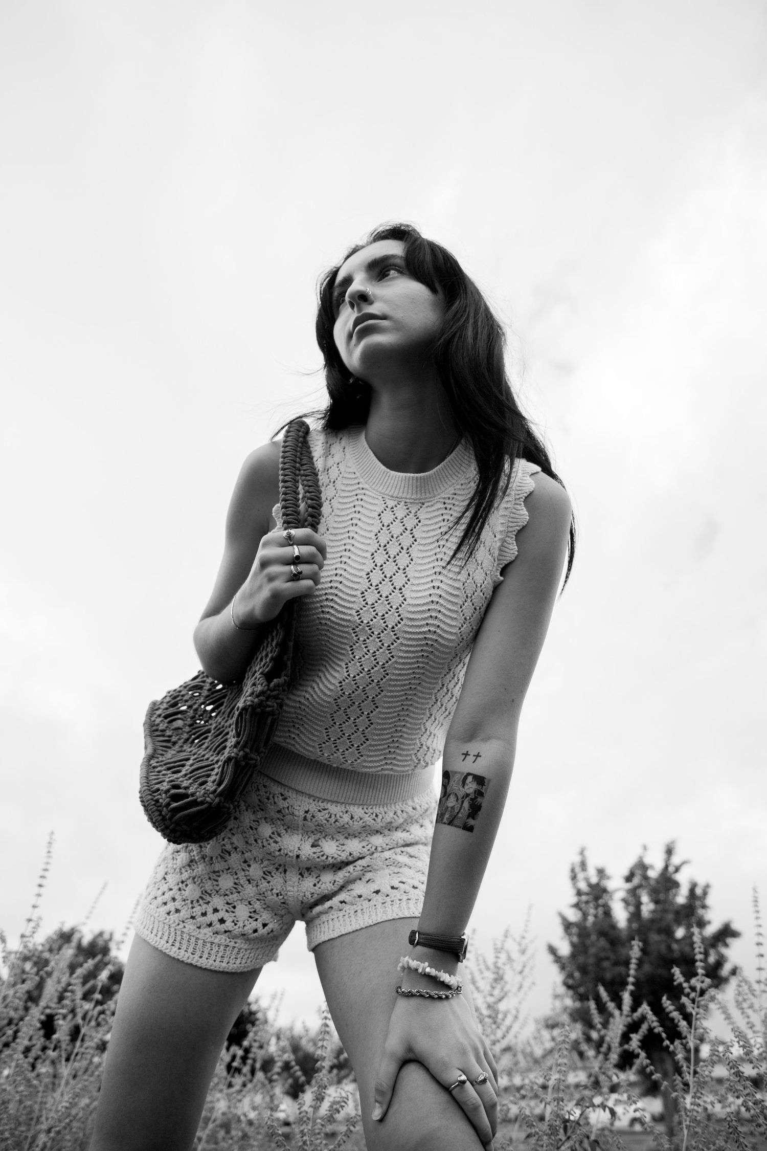 Young woman with mesh bag in a field, black and white fashion photography.