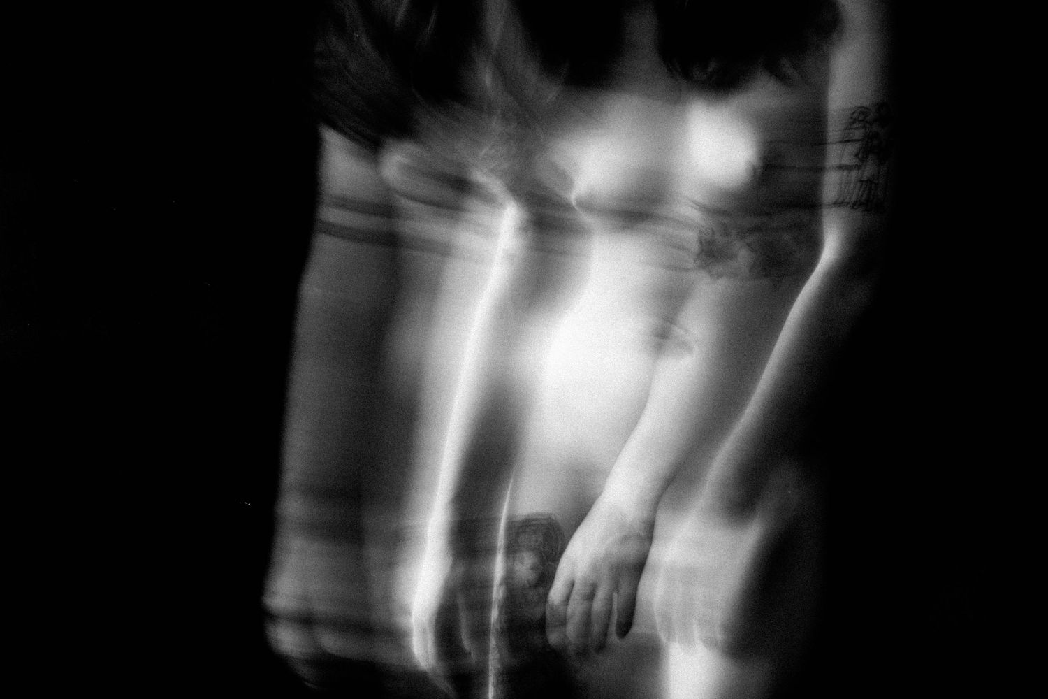 Abstract black and white multiple exposure nude art photography with motion blur effect.