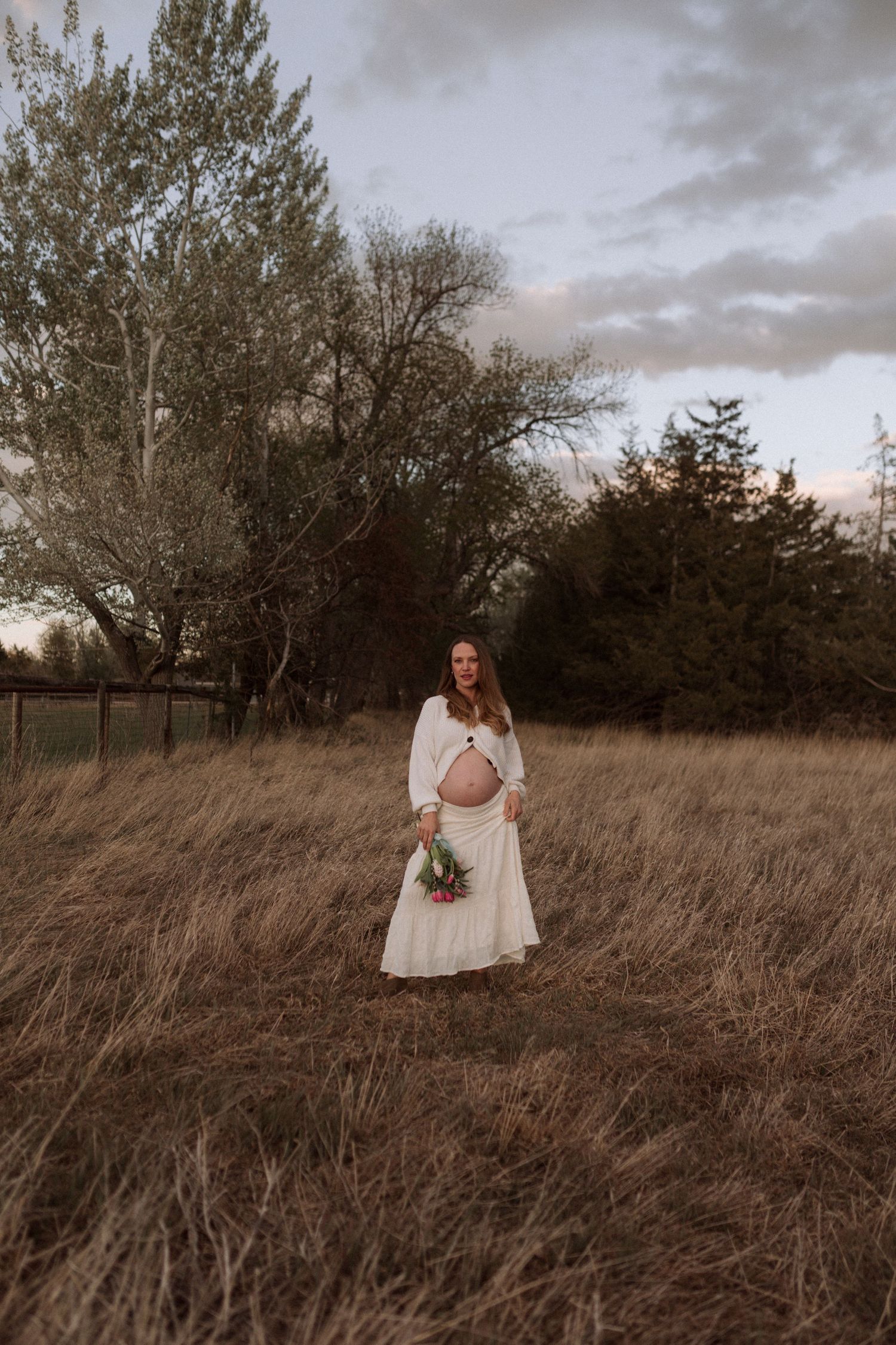 Outdoor maternity portrait with flowing dress in Colorado field