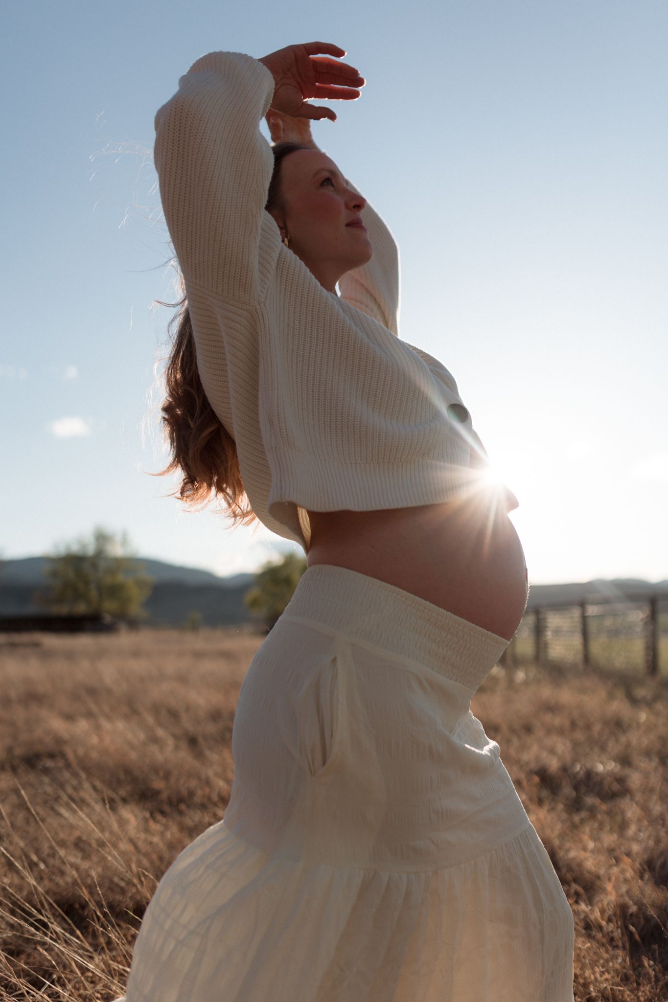 Outdoor maternity portrait with flowing dress in Colorado field