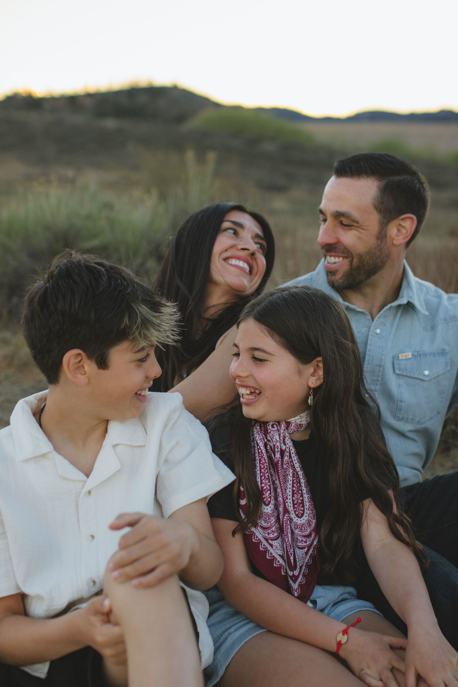 Young family cuddling on blanket during outdoor family photos