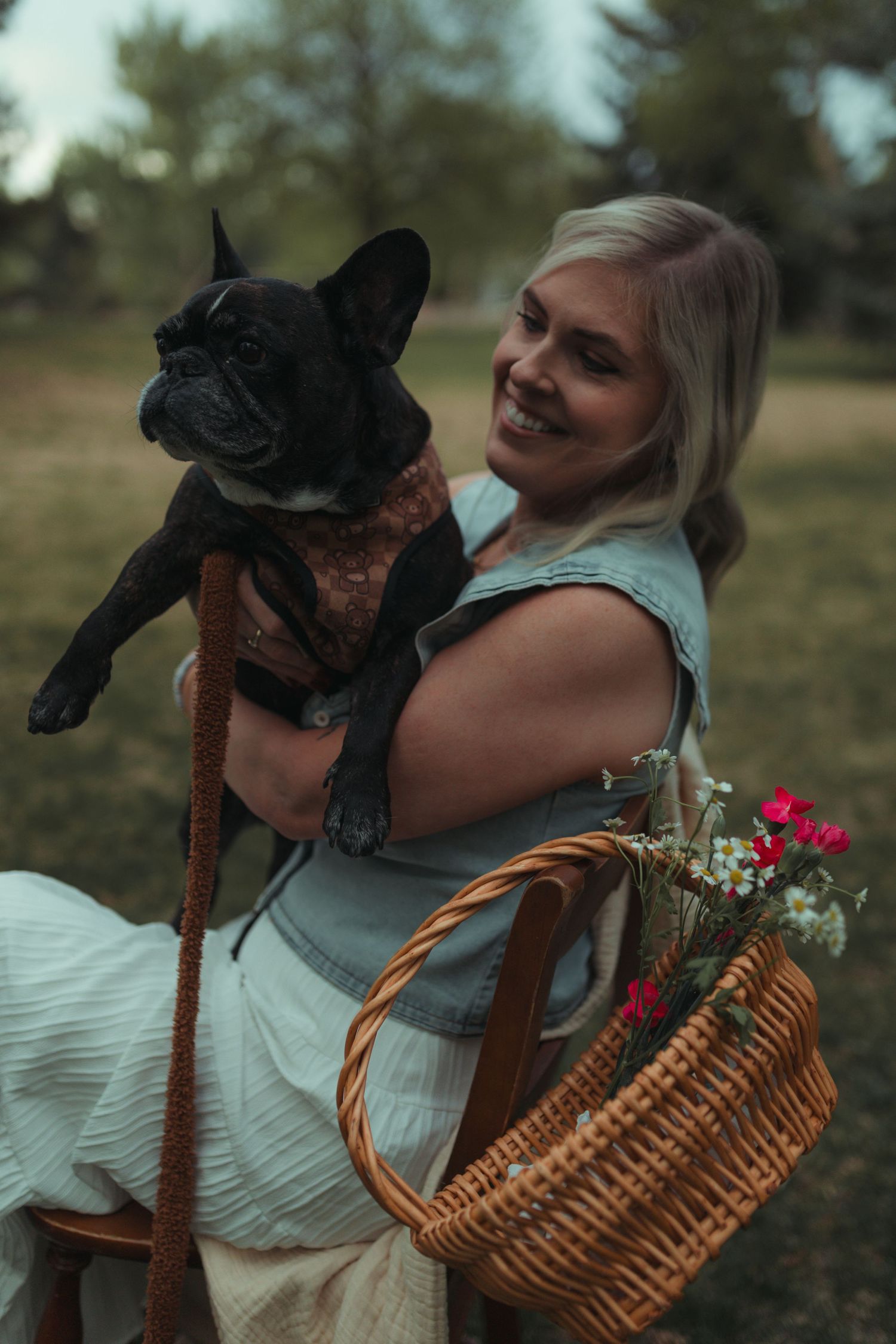 portrait of woman and her dog with soft natural light flowers in a northern colorado park