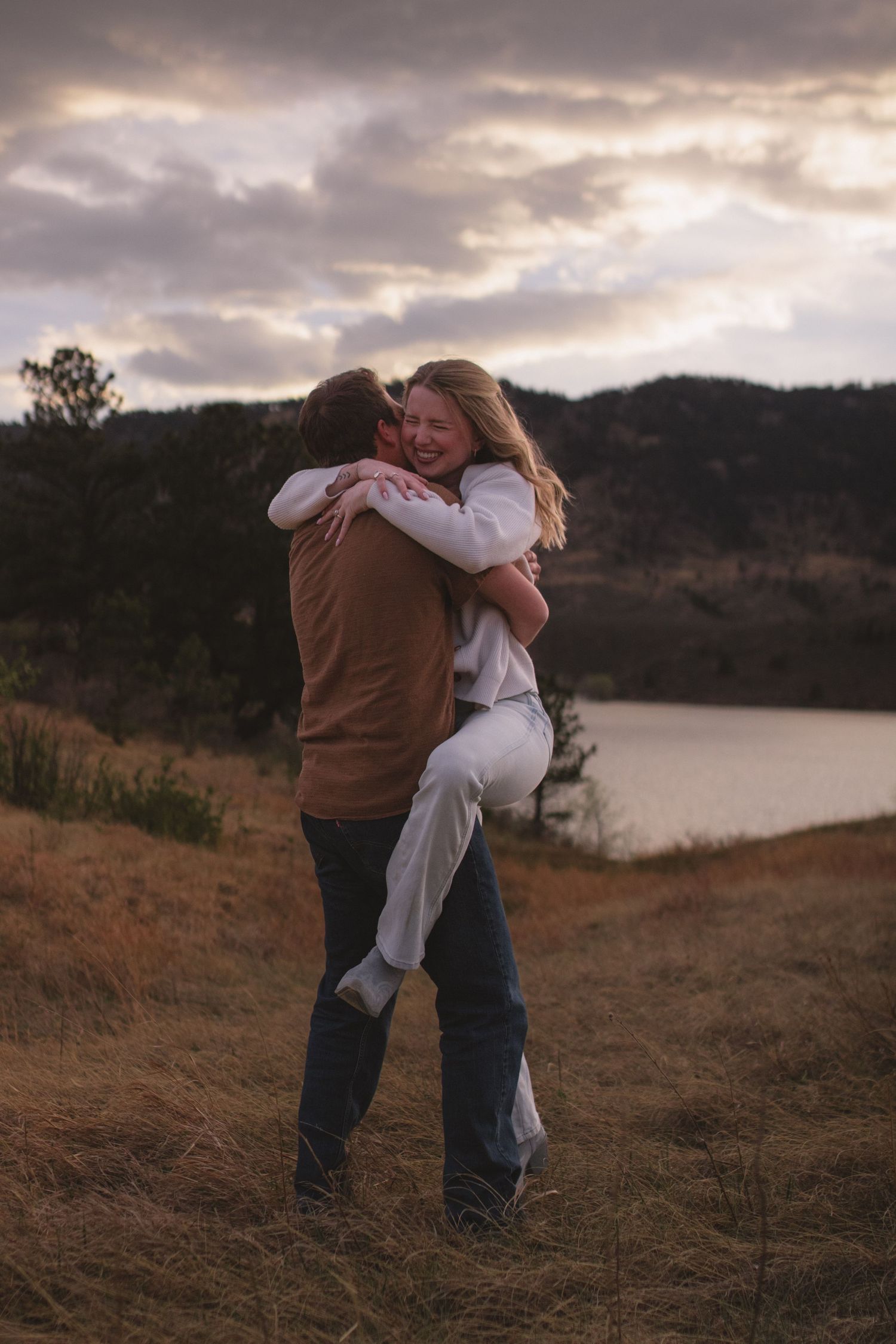 Young couple cuddling during backyard lifestyle session