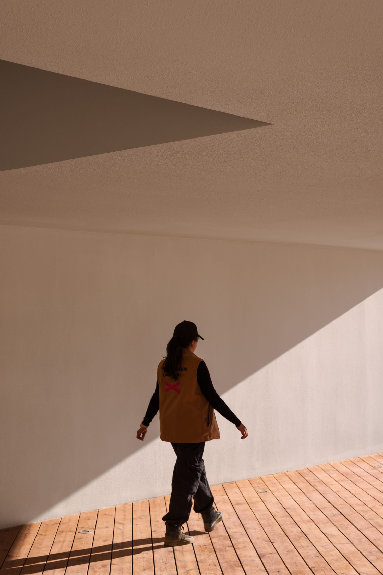 A woman walks through the architecture of the Desert X AlUla 2024 visitor center in AlUla Saudi Arabia