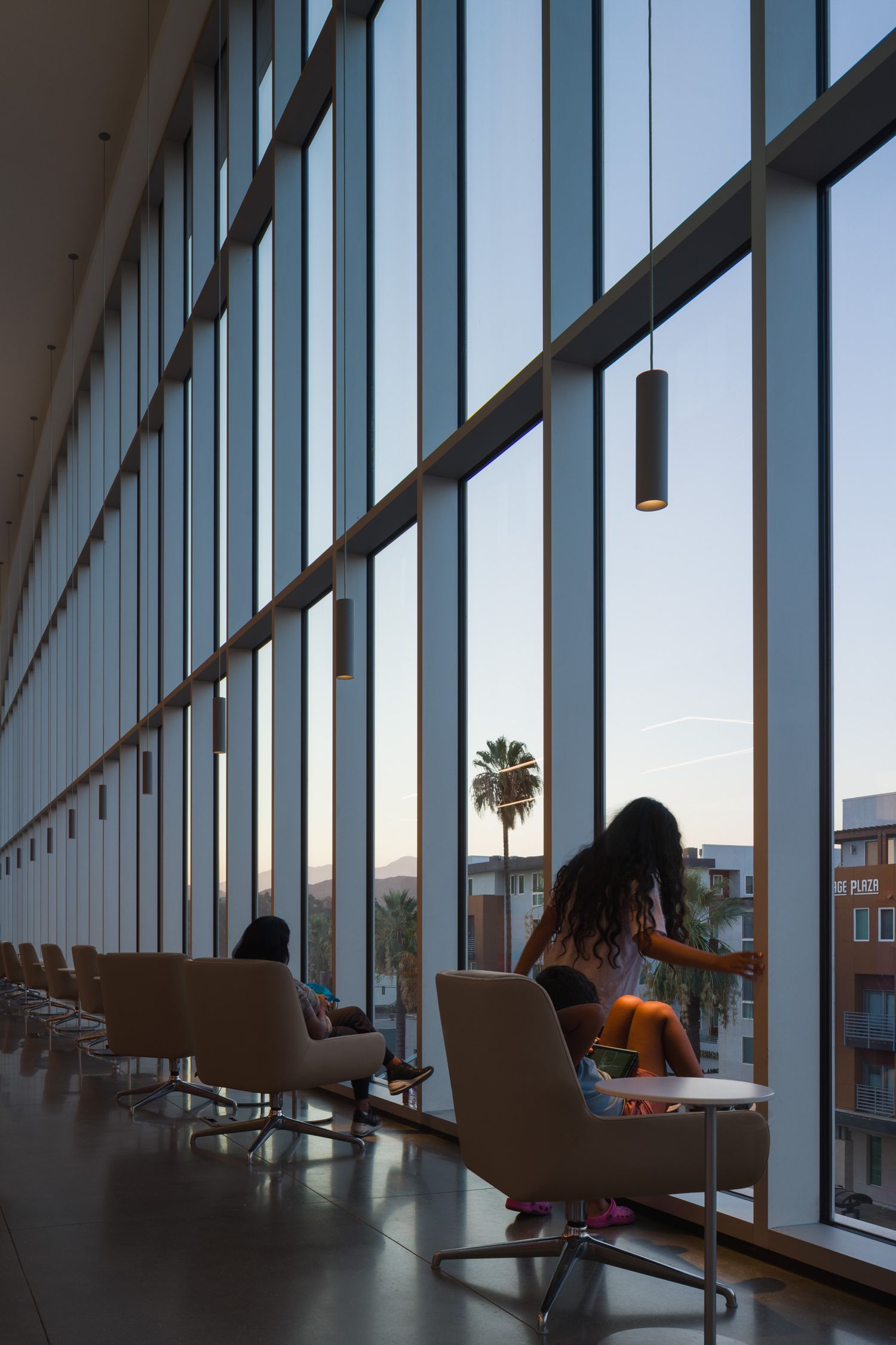 Kids looking out of the window from inside of the Riverside Main Library