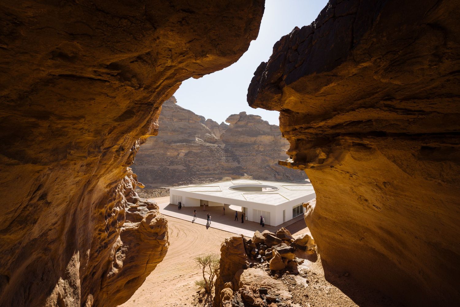 View of Desert X AlUla 2024 visitor center by KWY.studio framed with a nearby rock outcropping